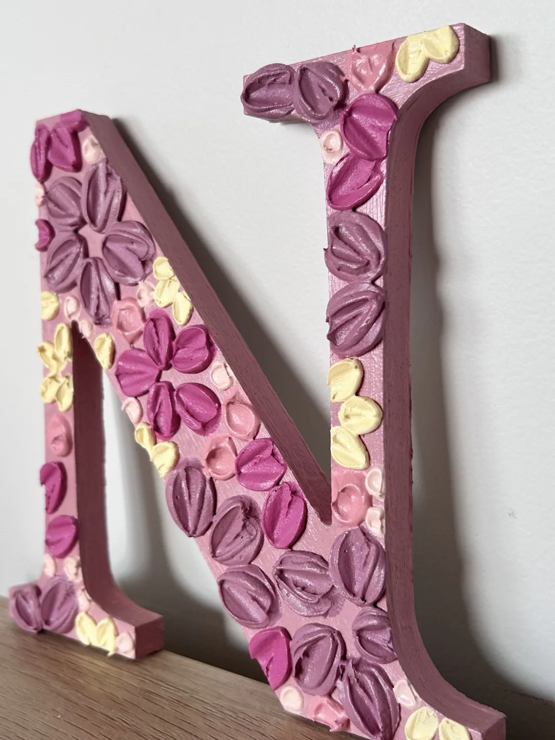 Close-up of a textured hand-painted floral letter